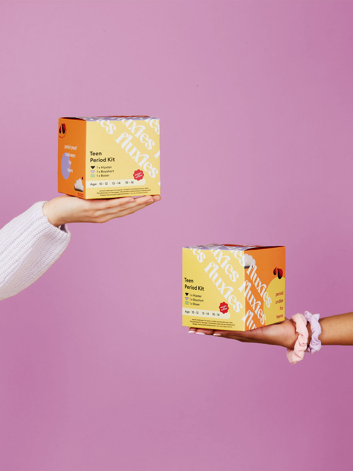 hands holding two boxes of teen period kit