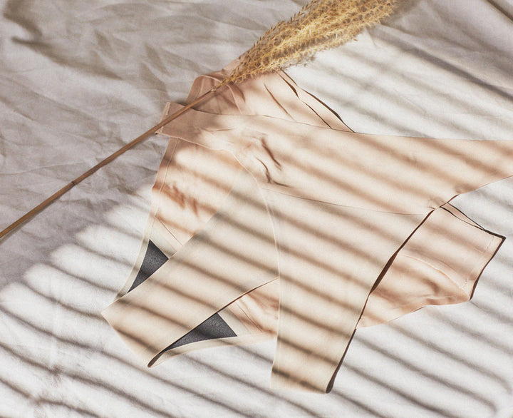 beige seamless period underwear on bed